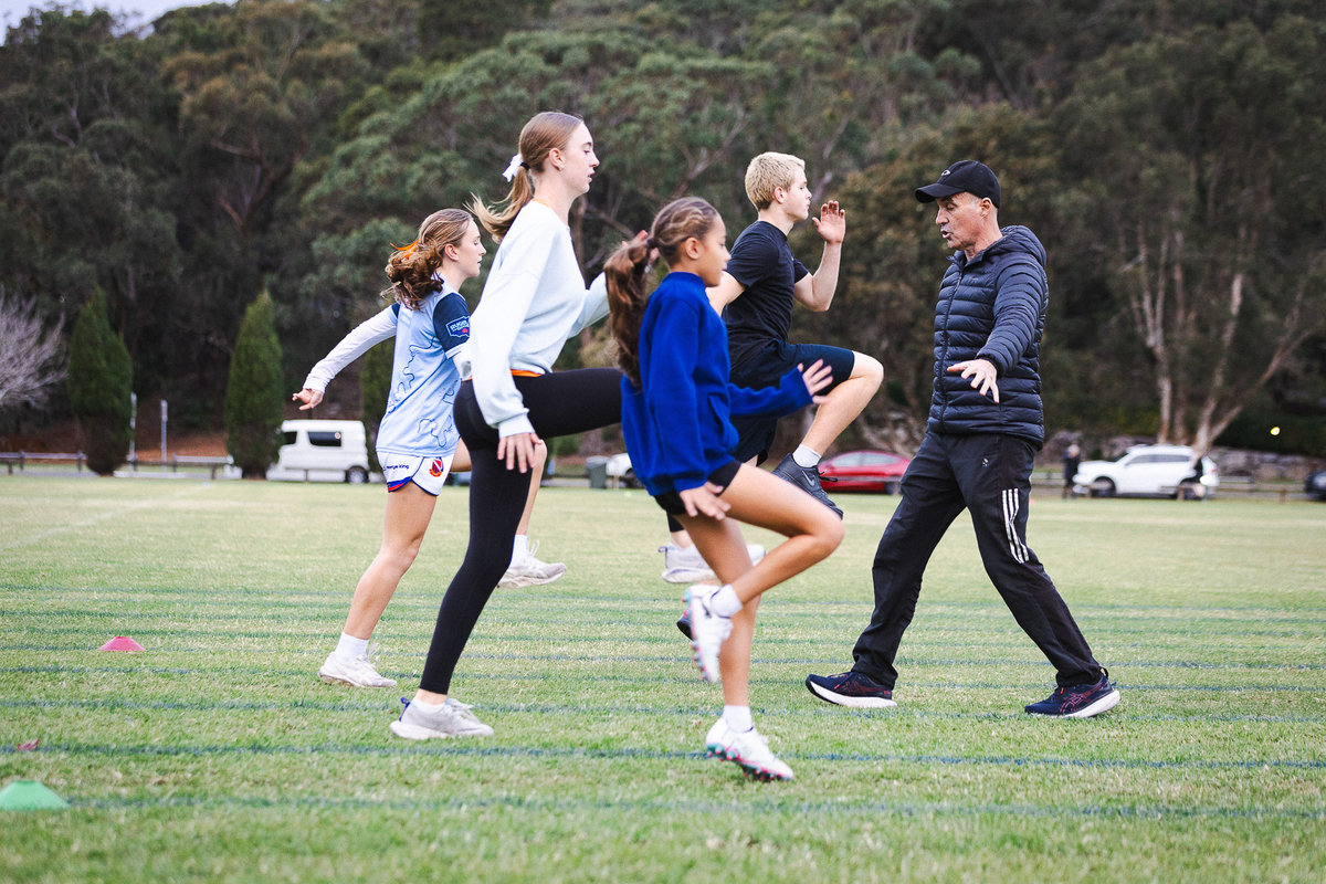 Coach Gary Theodore leading running mechanics drill with junior athletes at Narrabeen